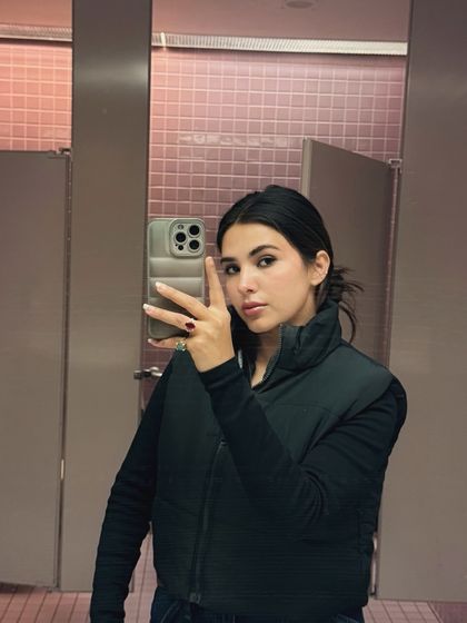 Another college outfit mirror selfie, this time featuring a black vest. This shows how I can create a lot of content variety with simple, relatable pieces.