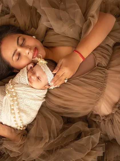 A mother rests with her newborn in a sea of beautiful brown tulle. An artistic and loving mother-and-child portrait.
