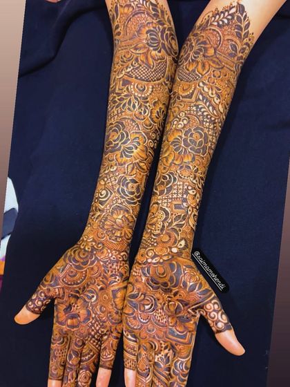 A full view of a completed elbow-length mehendi design, showcasing the incredible detail and artistry involved.