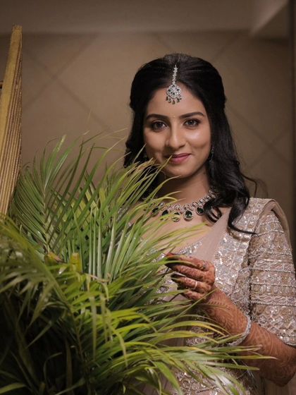 A modern reception look. The bride is wearing a beautiful beige lehenga, and her makeup is soft and elegant with a simple maang tikka.