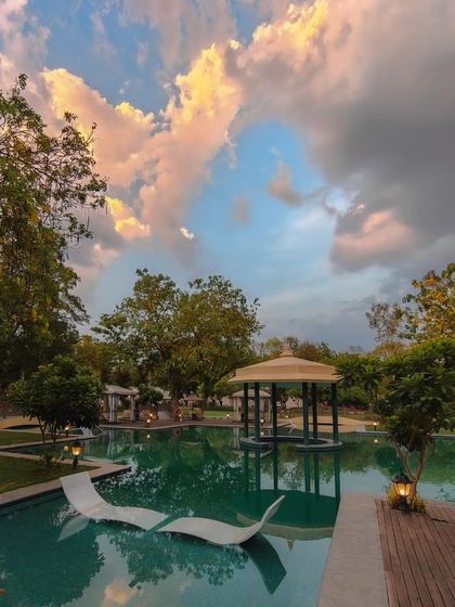 A beautiful resort pool in Gwalior under a dramatic evening sky. This image captures the relaxing and luxurious atmosphere of the property.
