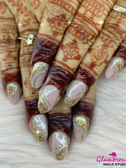 We absolutely love creating the perfect nails for our brides. This elegant look features a nude base with dazzling gold glitter swirls, designed to beautifully complement the intricate mehndi. It's the ultimate bridal manicure for your special day.