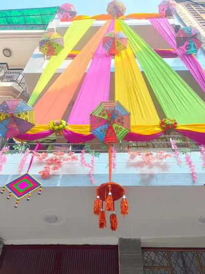 A wider view of the balcony and facade, showcasing a dense arrangement of colourful drapes and decorative elements.