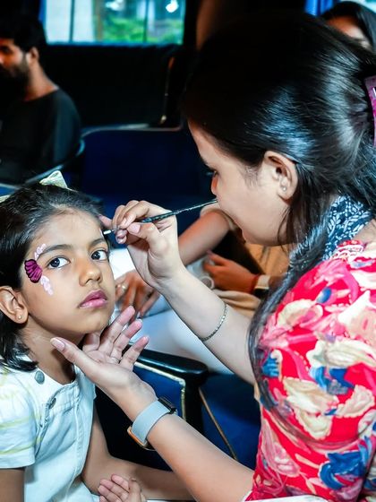 A face painting station is a wonderful addition to any creative party. Here, a young guest is getting a beautiful butterfly painted on her cheek.
