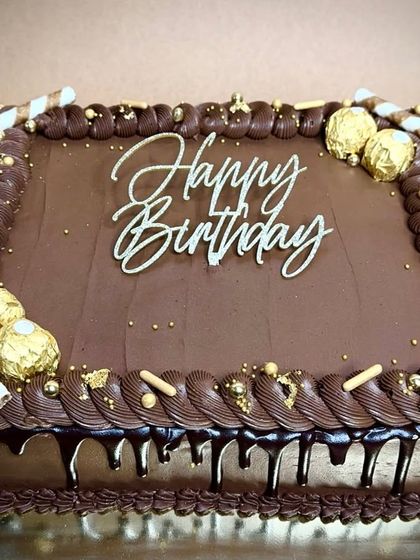 Our signature ultimate chocolate cake, reimagined as a rectangular sheet cake. It's decorated with Ferrero Rocher, chocolate wafer rolls, and a rich chocolate drip for the ultimate chocolate lover's birthday.
