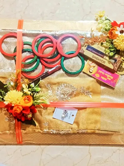 This is a traditional gift packing for a ceremony, containing a sari, bangles, sindoor, and other essentials. I arrange everything neatly and decorate it with flowers.