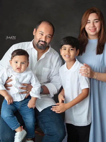 A lovely family of four posing for a classic portrait. The simple, coordinated outfits in white and blue create a timeless and elegant look.