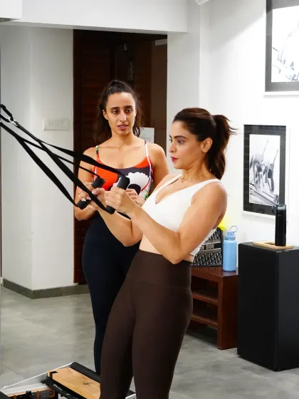 Aamna Shariff is all focus as she works her arms and back on the reformer. This exercise is excellent for building upper body strength and improving posture, creating a strong and sexy back.