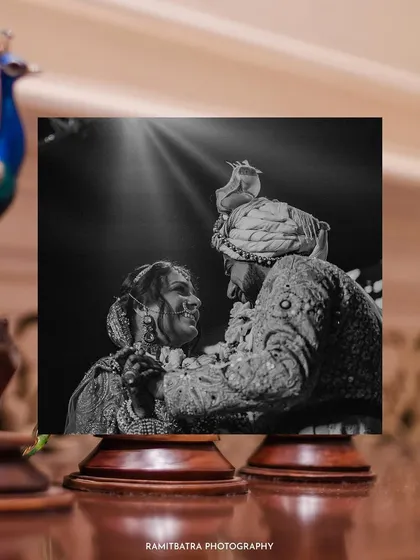 A creatively framed black and white shot of the couple during their Varmala, exuding timeless romance.