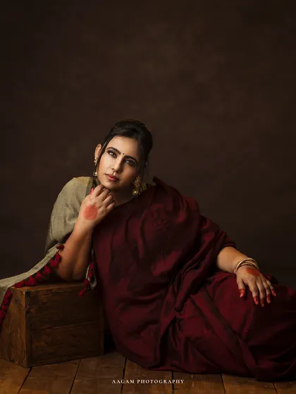 A relaxed, reclining pose from the same session. The red alta on her hand and feet adds a traditional and artistic touch.