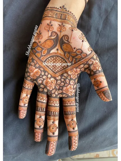 Another view of the twin peacock design. The details on the fingers, with tiny turtles and floral bands, complement the main design on the back of the hand perfectly.
