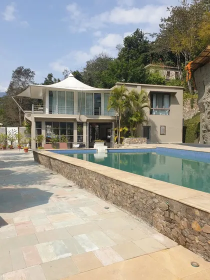 For this project, we designed a modern villa that opens up to its natural surroundings. The structure features large glass walls and a spacious patio that seamlessly connects the living areas to the swimming pool and the hillside beyond.