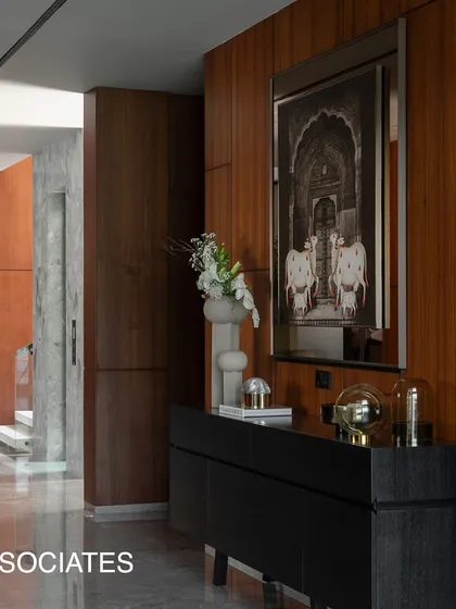 The entrance corridor combines rich woodwork with framed art and a sleek console, creating a gallery-like experience that welcomes you into the home.