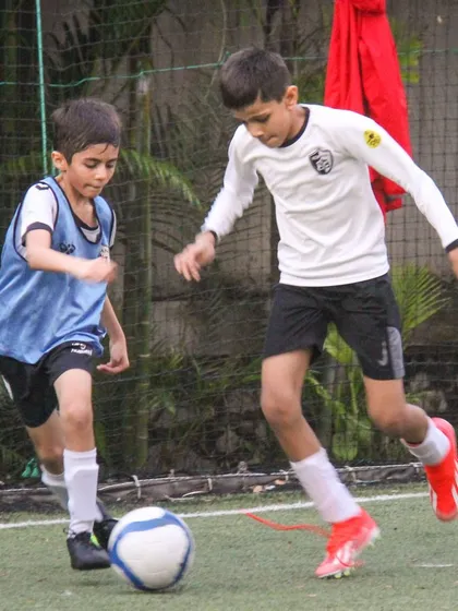 Two players challenge for the ball in a 1-on-1 duel, demonstrating the competitive edge and determination fostered in our training.
