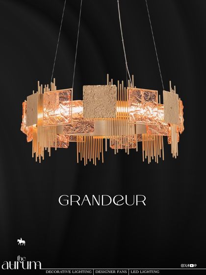 The 'Grandeur' chandelier lives up to its name with a bold, sculptural design. The mix of textured rose-gold plates and vertical rods creates a fixture that feels both artistic and architectural, perfect for a contemporary dining space.