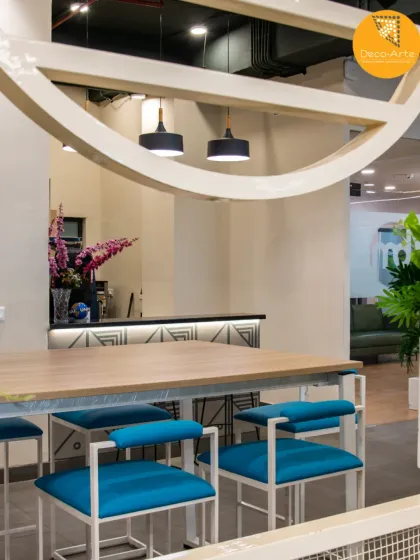 A refreshing approach to office breakout areas. This communal table at Brandman, with its vibrant blue seating and architectural frame, is designed for informal meetings and collaborative energy.