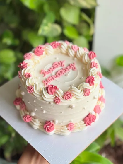 A delicate and sweet anniversary cake. This design features soft pink and white piping with tiny edible pearls for a simple yet elegant celebration.