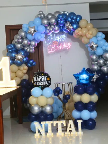 A compact space theme decoration perfect for home parties. It features a circular balloon arch, a neon sign, and a light-up number '1'.