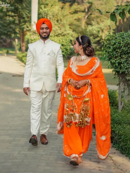 A full-length shot of the couple walking together during their pre-wedding shoot. It showcases their coordinated outfits and the easy, comfortable chemistry between them.