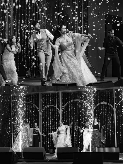 A collage of energetic sangeet moments in black and white. From the couple's dance to the group performances, these shots capture the dynamic and celebratory spirit of the evening.