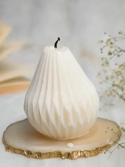 Our pear-shaped candle, burnt down slightly, resting on a gold-rimmed agate coaster. A beautiful piece for the new year.