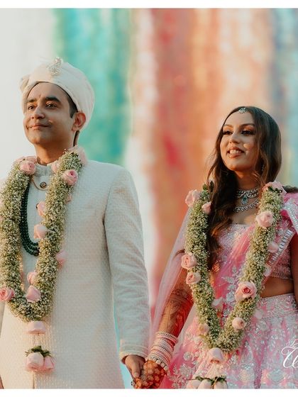 The couple, hand-in-hand, framed against a colorful backdrop, a beautiful portrait of their union.