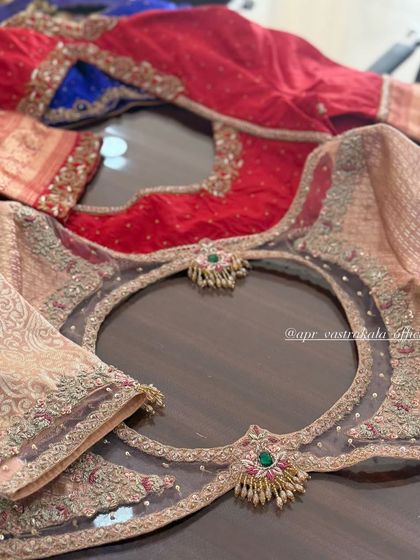 A collection of blouses showcasing various back cutout designs. The one in the foreground features a sheer net panel with a circular cutout and jewellery-style motifs.