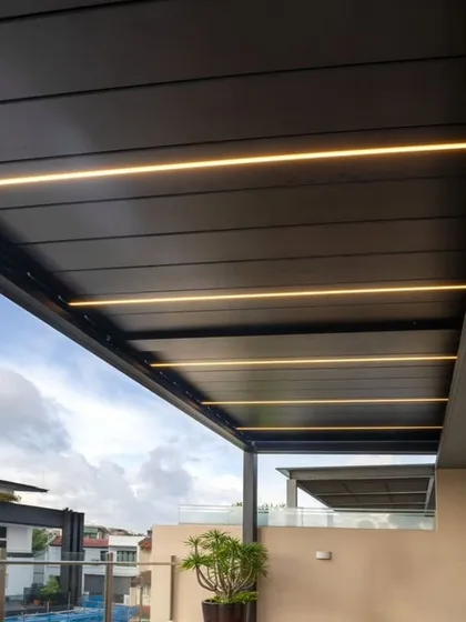 This image showcases a solid, opaque pergola roof with integrated linear LED lighting. This option provides complete shade and weather protection while offering a sleek, modern ceiling with built-in illumination.