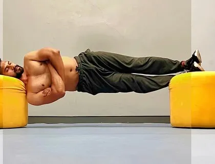 Progress is the goal. This side plank hold, supported by two ottomans, is an intense core exercise that challenges stability and endurance.