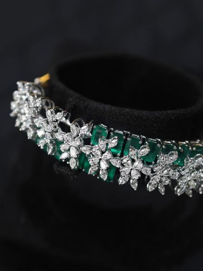 Diamonds and Emeralds are forever sparkling and always in style. This bracelet, with its floral diamond motifs over a band of emeralds, is a perfect accessory for any special occasion.