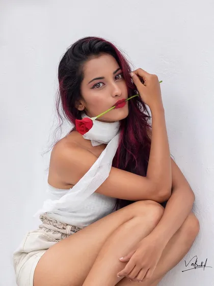 The full-color version of our romantic rose portrait. The vibrant red of the model's hair complements the soft tones of her outfit and the simple white background.