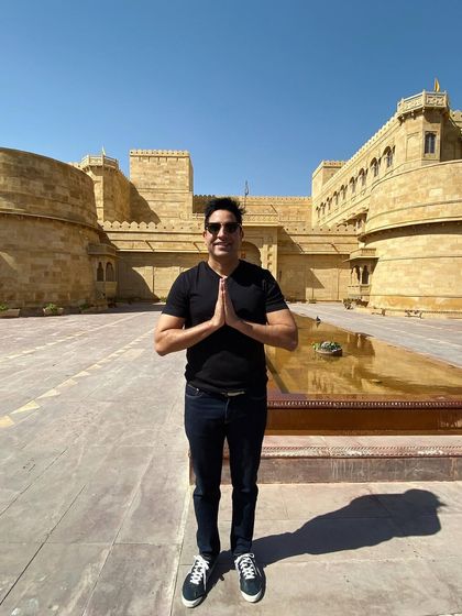 A respectful 'Namaste' upon arriving at the stunning Suryagarh in Jaisalmer. This venue offers a unique desert fortress experience for a truly memorable destination wedding.