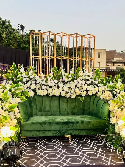 A detailed shot of the green velvet sofa and the abundant white floral arrangements, perfect for couple portraits.