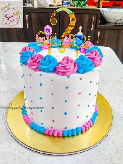 He or she? What will the baby be? This tall gender reveal cake is decorated in pink and blue polka dots and swirls, keeping the secret safe until it's time for the big slice.