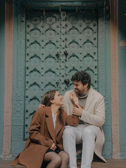 A sweet moment on the steps of a beautifully decorated doorway in Delhi. The vibrant colors and intricate details of the location complement the couple's connection.