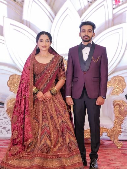 A full-length portrait of the couple. The bride's opulent lehenga is balanced with a classic makeup look that enhances her beauty without competing with the outfit.