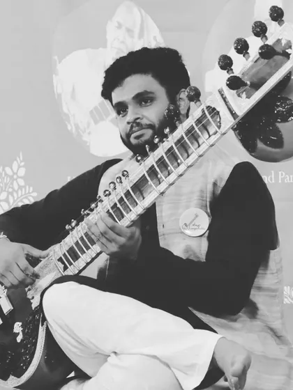A moment of performance, seated on stage. This traditional posture helps in maintaining balance and control over the instrument.