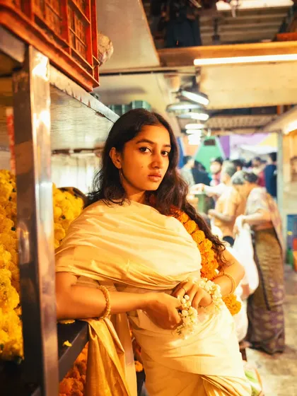 Leaning against a flower stall, this shot has a relaxed and authentic feel. The composition uses the surrounding elements to tell a story.