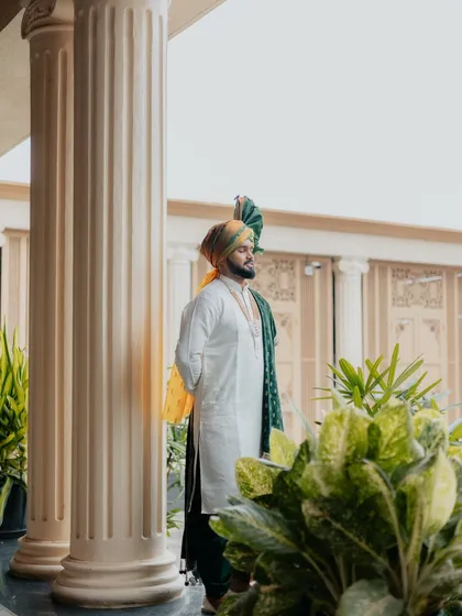 A handsome portrait of the Maharashtrian groom in his traditional wedding outfit, looking thoughtful and ready for the ceremony.