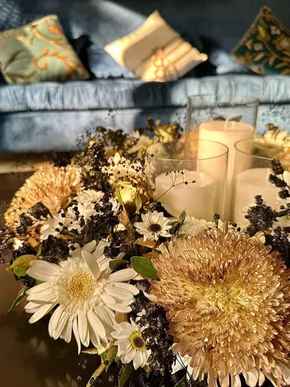 The warm glow of the candles in this centerpiece creates a cozy and inviting ambiance, perfect for an intimate gathering at home.