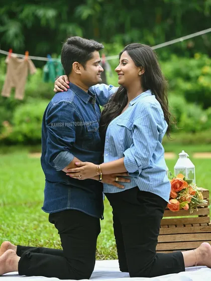 A lovely outdoor maternity picnic scene, with the couple sharing an intimate moment in a lush green park.