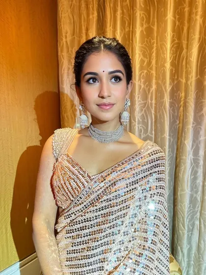 The side profile shows the beautiful, intricate hairstyle and the flawless finish of the makeup. It's a look that is elegant from every angle.