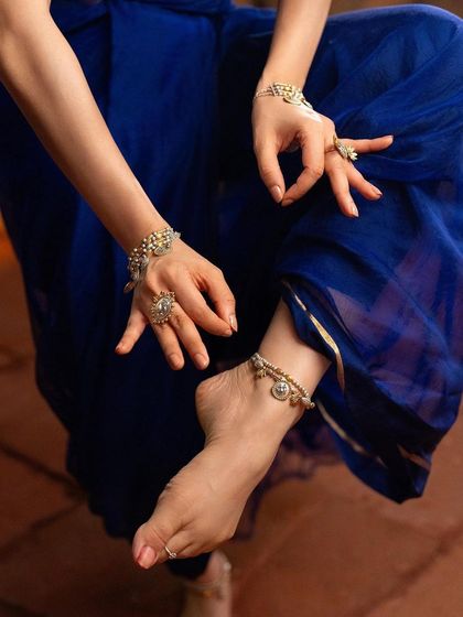A close-up on the details for a jewellery campaign. The focus is on the intricate hand and foot jewellery, an essential part of a classical dancer's adornment.