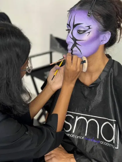 A shot of me in action, carefully painting the intricate details on the model's face for my fantasy exam project.