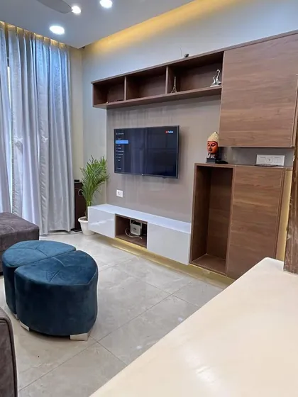 The TV unit in our Gurgaon project combines dark wood with a white console. We also added a small niche for placing decorative items like a Buddha statue.