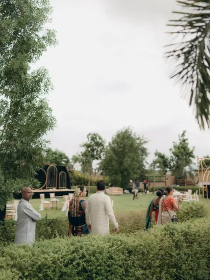 A wide shot of the outdoor wedding venue, showing the beautiful lawn and stage setup before the festivities begin.