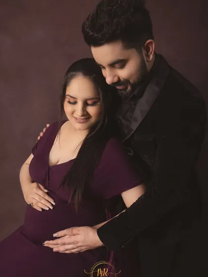 A classic and tender embrace. This portrait captures the quiet connection between partners as they both gently hold the baby bump.