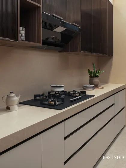 This kitchen showcases a sleek, minimalist aesthetic. The handle-less white lower cabinets and dark fluted upper cabinets create a beautiful contrast, while the countertop is kept clear for a clean, uncluttered look.