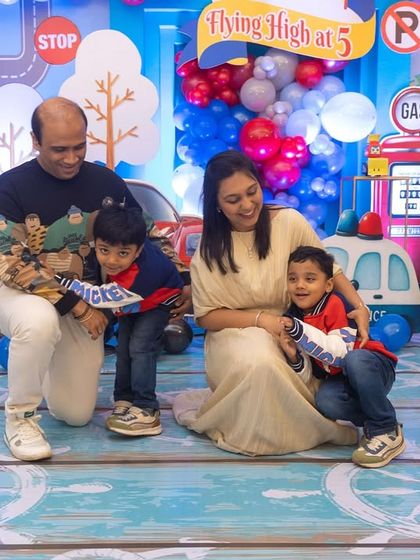 A heartwarming family photo with the birthday boys, Luv and Kussh. The colorful, detailed backdrop makes the photo even more special.