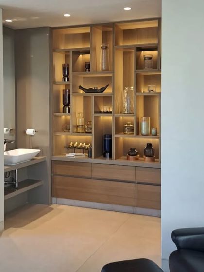 Detail of the spa area, showing the intricate custom cabinetry designed for storage and display. The warm wood and soft lighting contribute to the room's overall sense of peace and luxury.
